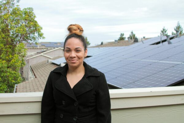 Woman on rooftop with solar panels in the background